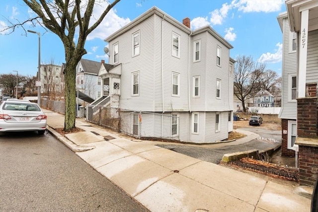 view of home's exterior with a residential view and a chimney