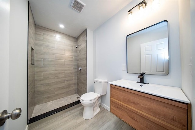 121 Horton St, Fall River, MA 02723 - bathroom featuring toilet, vanity, a tile shower, wood finished floors, and baseboards
