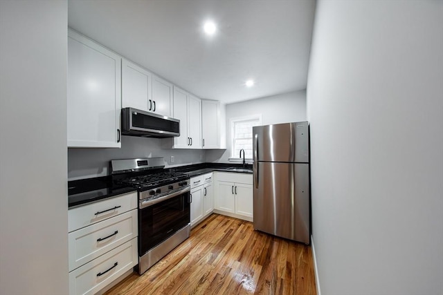 121 Horton St, Fall River, MA 02723 - kitchen with appliances with stainless steel finishes, a sink, white cabinetry, light wood-style flooring, and recessed lighting