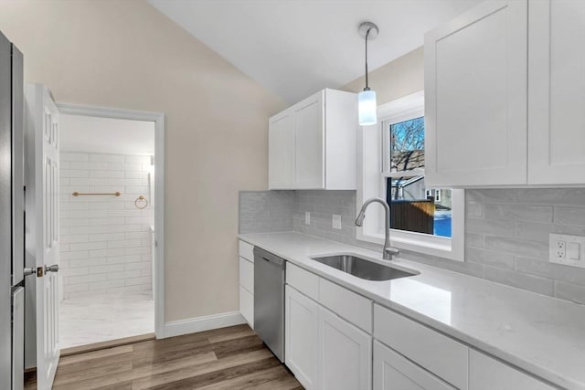 kitchen with white cabinetry, sink, stainless steel dishwasher, hardwood / wood-style floors, and pendant lighting