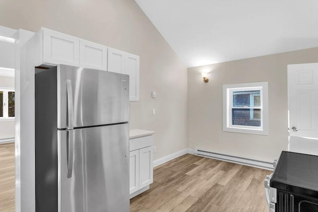 kitchen with lofted ceiling, a baseboard heating unit, stainless steel fridge, light hardwood / wood-style floors, and white cabinetry