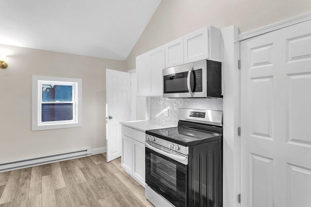 kitchen featuring stainless steel appliances, tasteful backsplash, light hardwood / wood-style floors, vaulted ceiling, and white cabinets