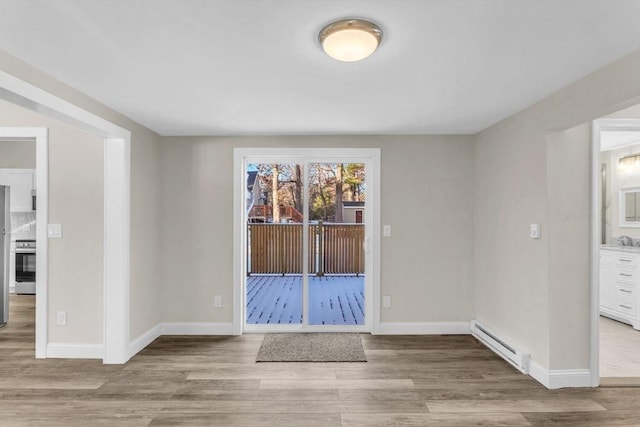 empty room featuring light hardwood / wood-style flooring and a baseboard heating unit