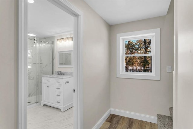 bathroom featuring wood-type flooring, vanity, and walk in shower