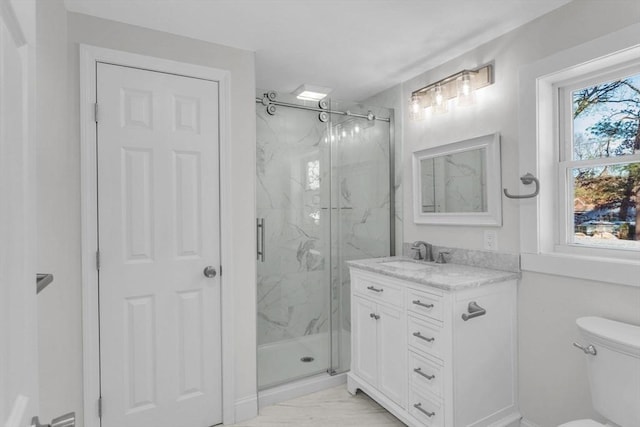 bathroom featuring vanity, toilet, and a shower with door