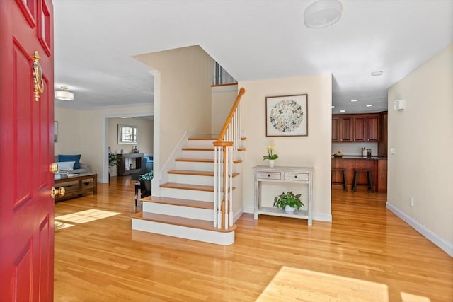 foyer with recessed lighting, stairway, light wood-style flooring, and baseboards