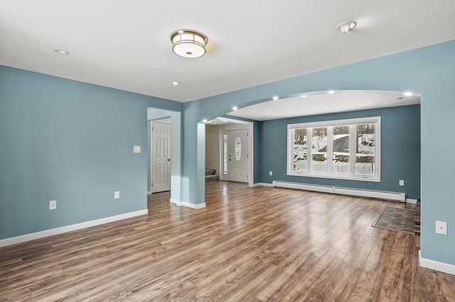 unfurnished living room with hardwood / wood-style flooring and a baseboard radiator