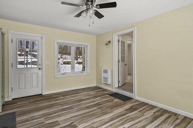 interior space featuring ceiling fan, hardwood / wood-style floors, and heating unit