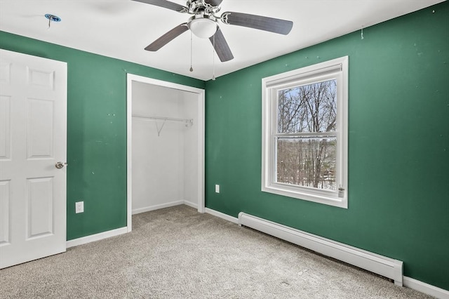 unfurnished bedroom with ceiling fan, carpet flooring, baseboard heating, and a closet