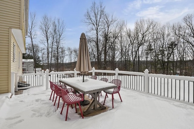 snow covered patio with a deck