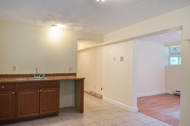 169 Lyman Rd, Berlin, MA 01503 - kitchen featuring baseboard heating, light tile patterned flooring, and dark stone counters