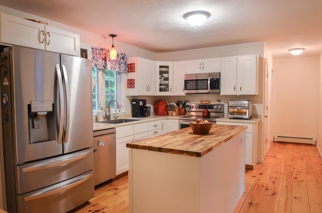 169 Lyman Rd, Berlin, MA 01503 - kitchen featuring appliances with stainless steel finishes, butcher block countertops, a baseboard radiator, white cabinets, and light wood finished floors