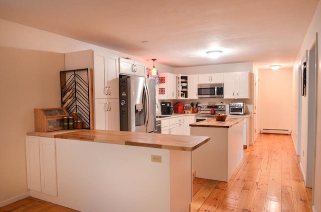 169 Lyman Rd, Berlin, MA 01503 - kitchen with wooden counters, appliances with stainless steel finishes, a baseboard heating unit, a peninsula, and light wood finished floors