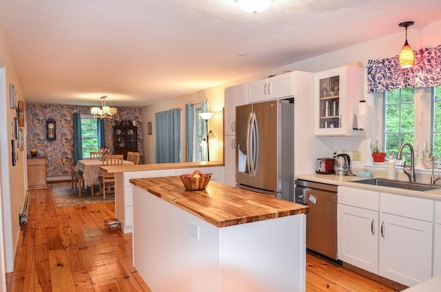 169 Lyman Rd, Berlin, MA 01503 - kitchen with stainless steel appliances, butcher block counters, light wood-style flooring, a chandelier, and white cabinets