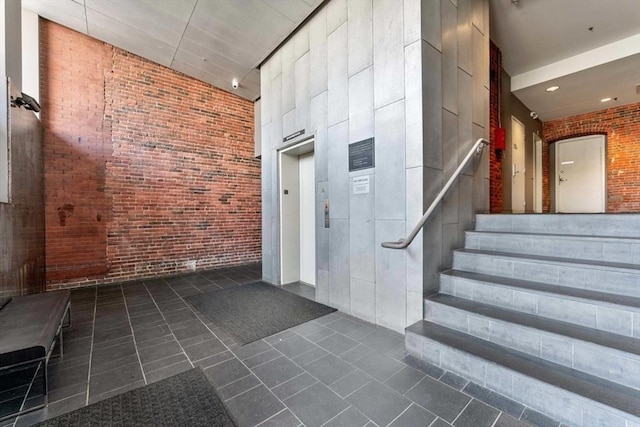 26 Stillman St Unit 4-5, Boston, MA 02113 - staircase with elevator, tile patterned flooring, and brick wall