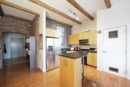 26 Stillman St Unit 4-5, Boston, MA 02113 - kitchen featuring a center island, dark countertops, beam ceiling, stainless steel appliances, and light wood-style floors