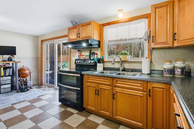 kitchen featuring black range with electric stovetop, sink, a wealth of natural light, and tasteful backsplash