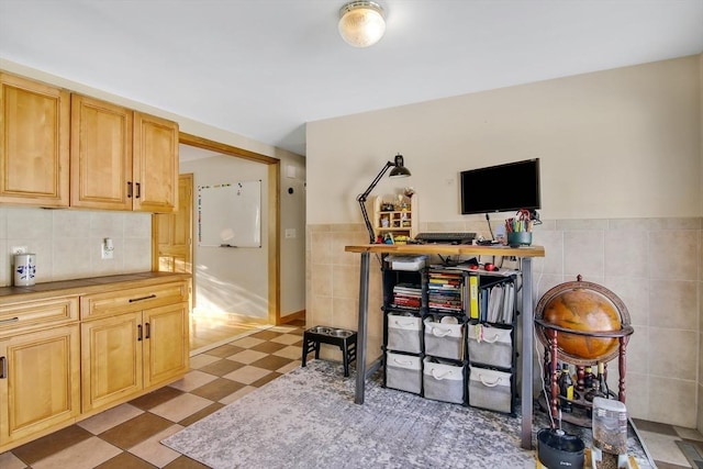 interior space featuring light brown cabinets and tile walls