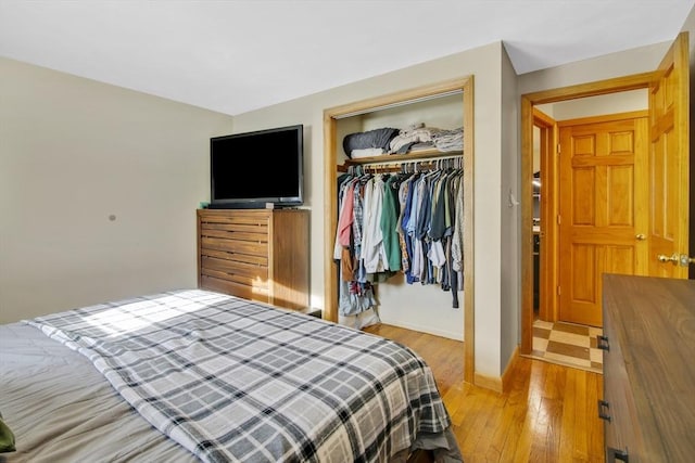 bedroom with light hardwood / wood-style floors and a closet