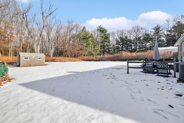 snowy yard with a shed