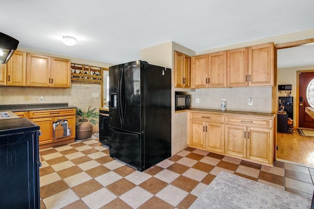 kitchen with light wood-type flooring, backsplash, extractor fan, black appliances, and light brown cabinets