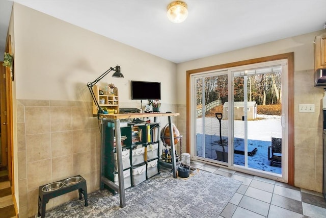 exercise room with tile patterned floors and tile walls