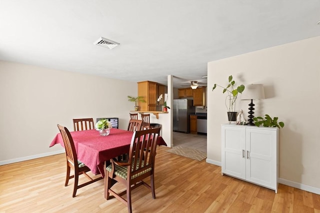dining space featuring light wood-style floors, baseboards, and ceiling fan