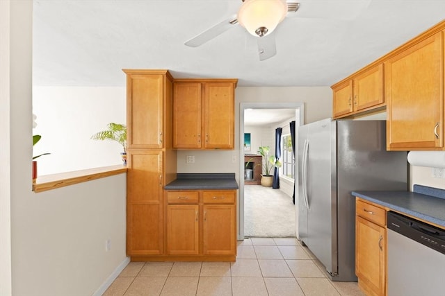 kitchen featuring stainless steel appliances, dark countertops, baseboards, a ceiling fan, and brown cabinets