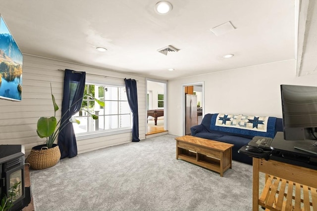 carpeted living room with a wood stove and recessed lighting