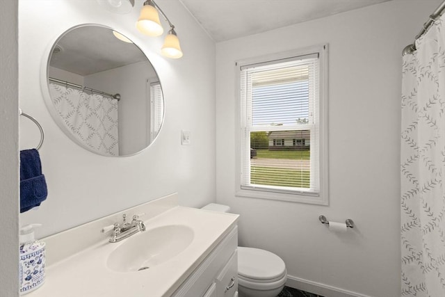 full bath featuring vanity, healthy amount of natural light, toilet, and baseboards