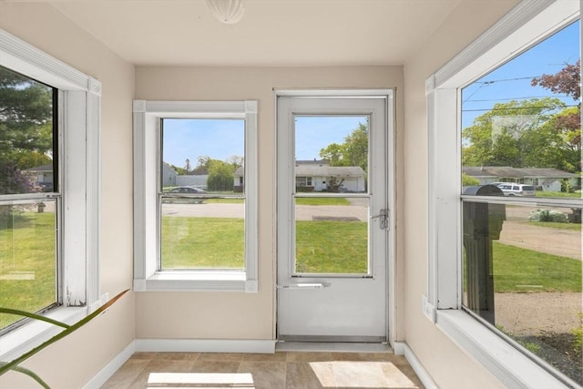 unfurnished sunroom with baseboards
