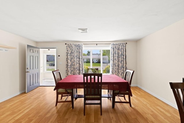 dining room featuring light wood-style flooring and baseboards