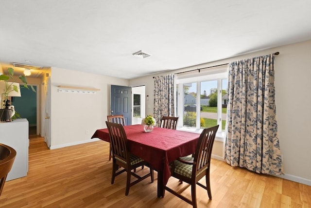 dining space featuring baseboards and light wood-style floors