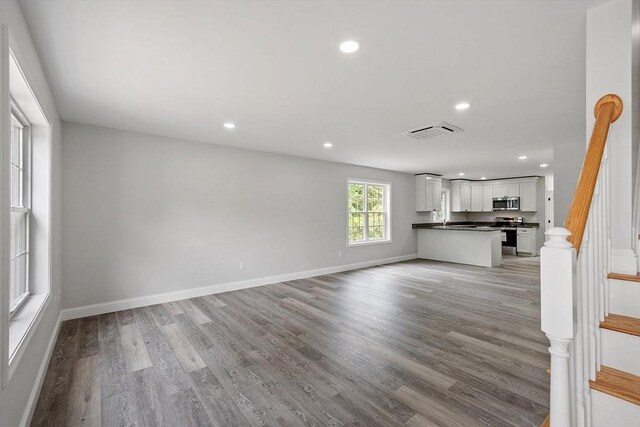 572 Pleasant St, Athol, MA 01331 - unfurnished living room with wood finished floors, recessed lighting, and stairway
