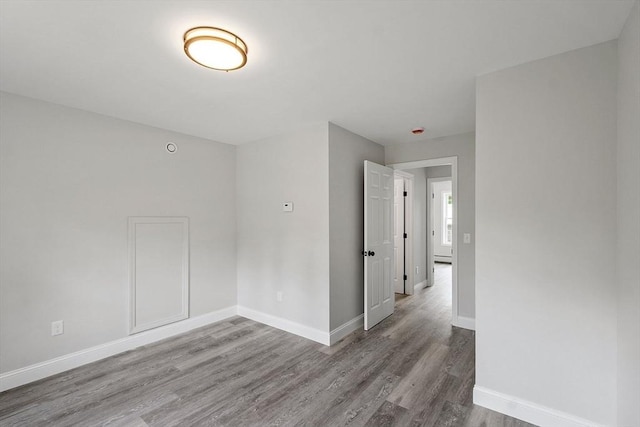 572 Pleasant St, Athol, MA 01331 - unfurnished room with wood finished floors and a baseboard heating unit