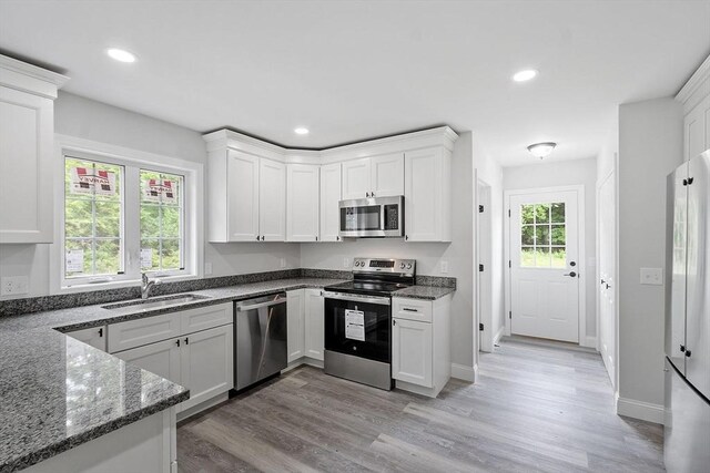 572 Pleasant St, Athol, MA 01331 - kitchen with stainless steel appliances, light wood-style floors, dark stone countertops, white cabinetry, and recessed lighting