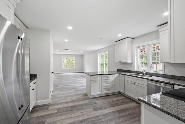 572 Pleasant St, Athol, MA 01331 - kitchen featuring stainless steel appliances, a peninsula, recessed lighting, dark wood-type flooring, and white cabinets