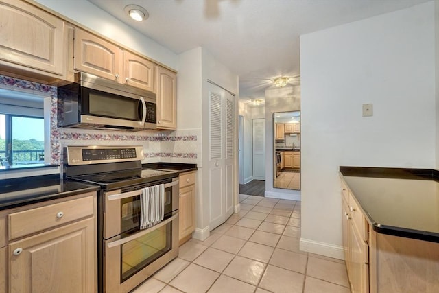 1 Summit Dr Unit 62, Reading, MA 01867 - kitchen with stainless steel appliances, dark countertops, light tile patterned floors, and light brown cabinetry