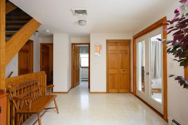 foyer entrance featuring a baseboard heating unit and french doors