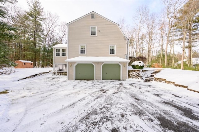 snow covered property with a garage