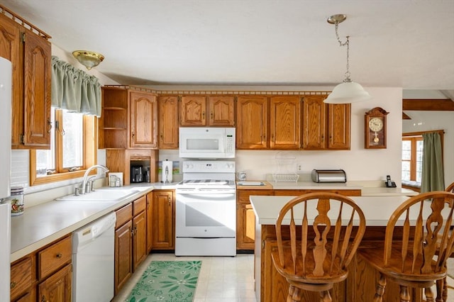 kitchen with pendant lighting, white appliances, a healthy amount of sunlight, and sink