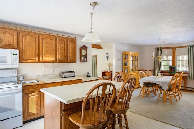 kitchen with hanging light fixtures, white appliances, a textured ceiling, and a kitchen island