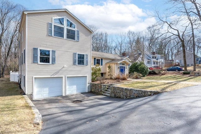 view of front of home featuring aphalt driveway, an attached garage, and a front lawn