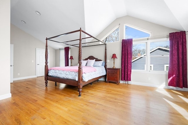 bedroom featuring high vaulted ceiling, baseboards, and wood finished floors