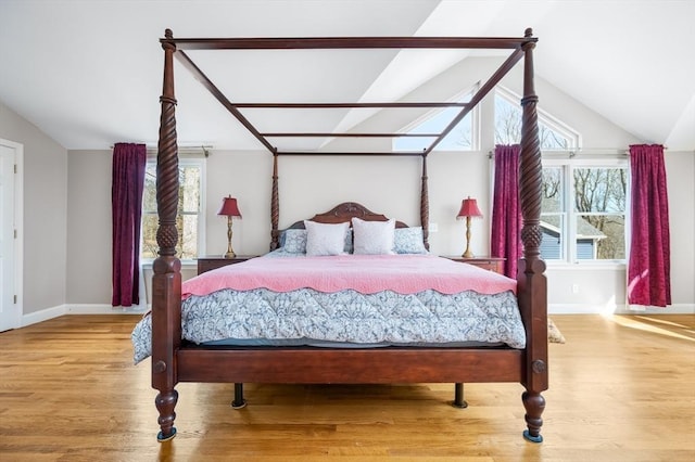 bedroom featuring multiple windows, wood finished floors, and vaulted ceiling