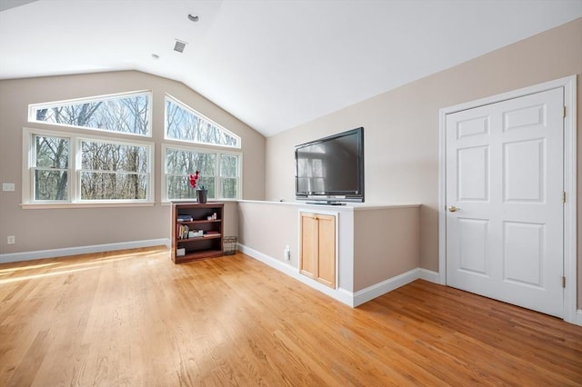 unfurnished living room featuring visible vents, baseboards, light wood-type flooring, and lofted ceiling