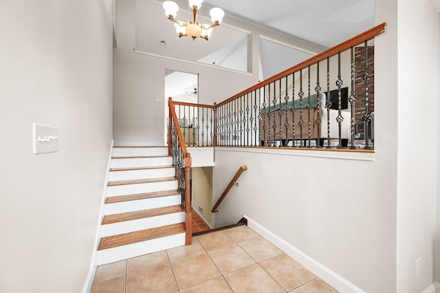 stairway with tile patterned floors, baseboards, a notable chandelier, and vaulted ceiling