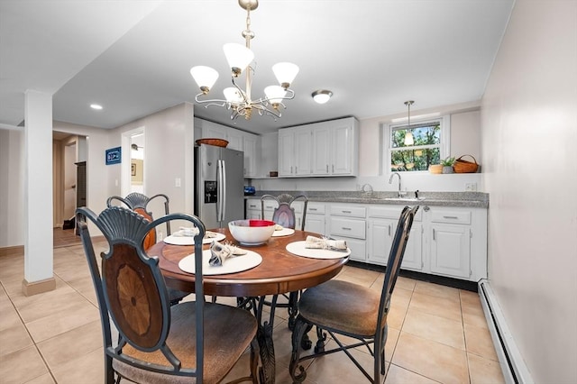 dining space featuring light tile patterned flooring, baseboard heating, a chandelier, and baseboards