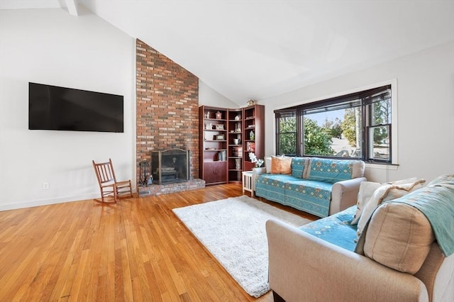 living room featuring vaulted ceiling, wood finished floors, a fireplace, and baseboards