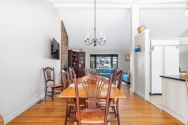 dining area featuring visible vents, baseboards, light wood-type flooring, and an inviting chandelier